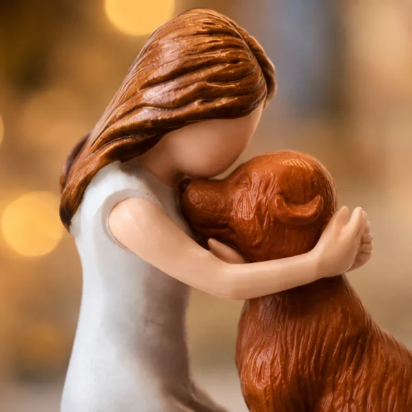 Close-up detail of dog mum angel figurine showing woman kissing brown dog tenderly
