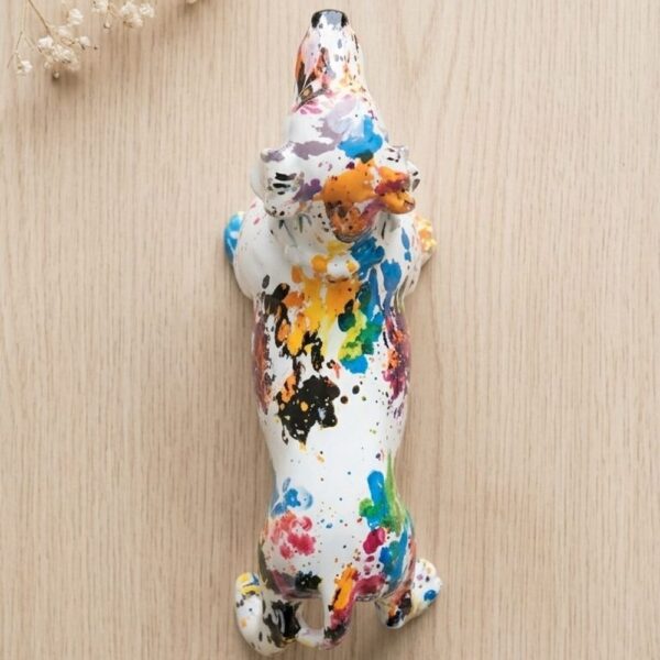 Colourful dachshund resin statue on creative art desk with paint brushes and sketchbook