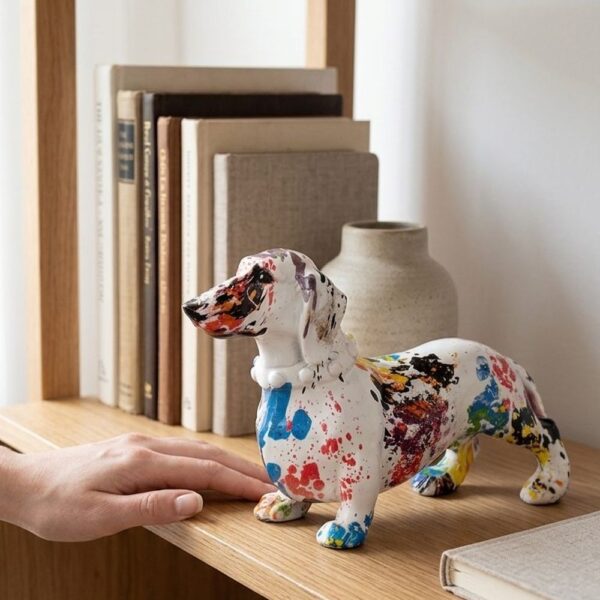 Colourful painted dachshund resin statue on modern shelf with art books and succulent